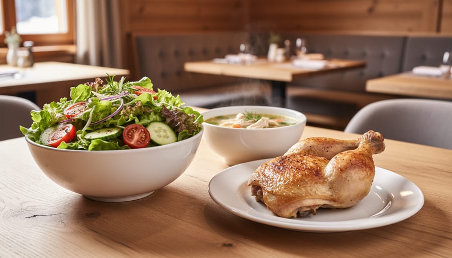 Close-up of a Swiss Chalet–style light meal with a house garden salad and chicken soup on a wooden table in a softly blurred dining room.